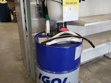 un fût bleu sur lequel est accrochée une pancarte, posé dans un garage