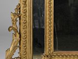 a gold frame with a mirror on it on a table
