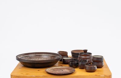 a wooden table topped with bowls and plates on it
