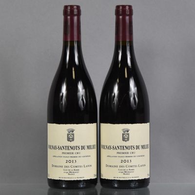 two bottles of wine sitting on top of a table next to each other