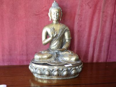 a statue of a buddha sitting on a wooden table