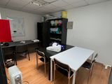 a room with a table, chairs, and a refrigerator in it
