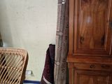 a wicker chair in the corner of a room next to a wooden cabinet