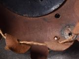 a close up of a brown leather bag with a metal handle