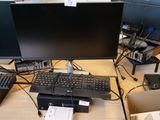 un bureau d'ordinateur équipé d'un clavier, d'un écran, d'une souris et d'autres appareils électroniques