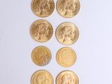 plusieurs pièces d'or sont disposées en ligne sur une surface blanche