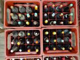 Des bouteilles de vin sont empilées dans une caisse rouge posée sur une table