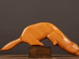an image of a wooden sculpture of a ferret on a block