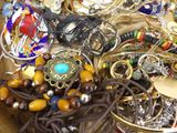 a close up of a bowl of jewelry on a table