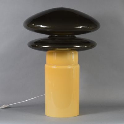 a black and yellow table lamp with a white cord on top of it