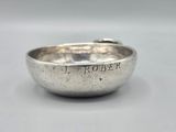 a close up of a silver bowl on a white surface