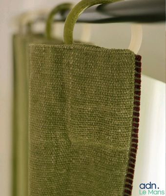 un gros plan sur une serviette verte accrochée à un rideau de douche