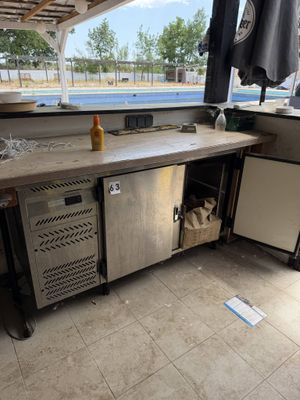an outdoor kitchen with stainless steel appliances and a sink