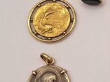 several different types of gold and silver charms on a white surface
