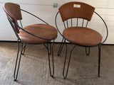 pair of mid century style chairs with leather seats and metal legs