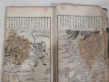 two old books sitting on a table with pictures on them