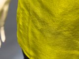 a close up of a person wearing a yellow shirt and black pants