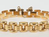 a close up of a gold bracelet on a white background