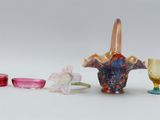 many different colored glass vases and glasses on the table
