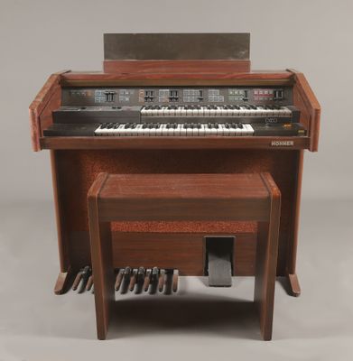 un petit piano en bois avec un banc en dessous