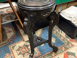 une petite table noire avec un plateau en bois, posée sur un tapis