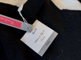 a black sweater with a pink label on it