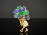 une broche plaquée or ornée de ballons bleus et verts