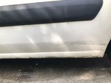 a white car with black trim parked on the side of the road