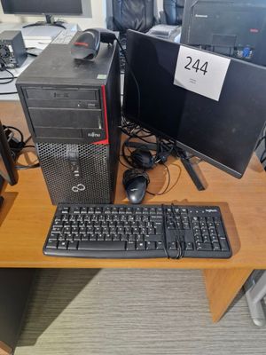 un ordinateur de bureau posé sur une table avec un clavier et une souris