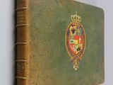 an old book with a picture of a coat of arms on it