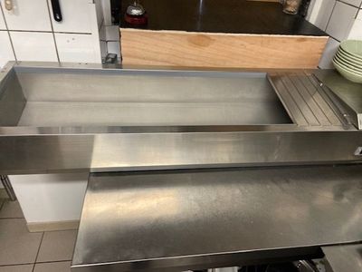 un évier en acier inoxydable au milieu d'une cuisine