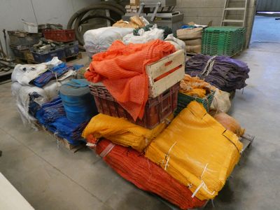 a pile of bags and a cart in a warehouse
