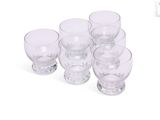 six verres posés les uns à côté des autres sur une surface blanche