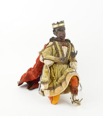 une figurine représentant un homme noir assis sur une chaise