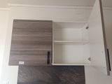 a cabinet with a door and a shelf above it
