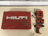 a drill and two batteries sitting on a table