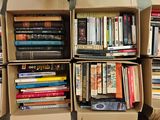 de nombreux livres rangés dans des cartons empilés les uns sur les autres