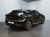 the rear end of a black car parked in a garage