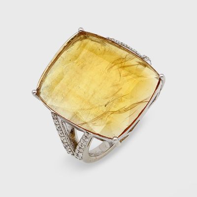 une image représentant une bague ornée d'une grosse pierre jaune entourée de diamants