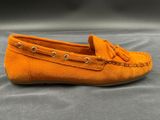 a close up of a pair of orange shoes on a gray surface
