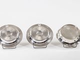 three silver metal knobs sitting on top of each other on a white surface