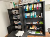 a black bookcase filled with lots of files in a room