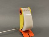 yellow and white tape dispenser sitting on top of a gray surface