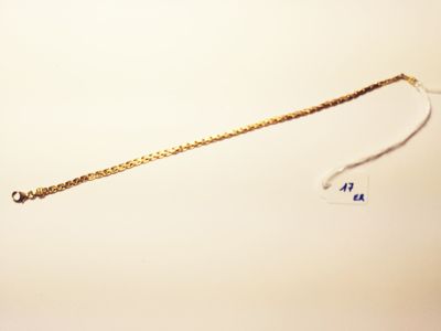 a gold chain that has been placed on a white surface
