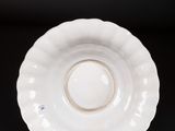a close up of a white plate on a black surface