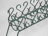 a green metal rack that has a bunch of hooks on it