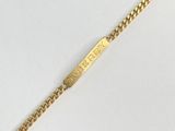 Gros plan sur un bracelet en or orné d'une barre