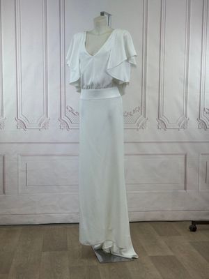 a white dress on a mannequin stand in a room