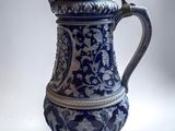 a blue and white vase with a lid on a table