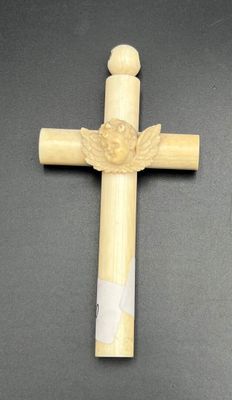 wooden cross with angel wings on it on a black surface
